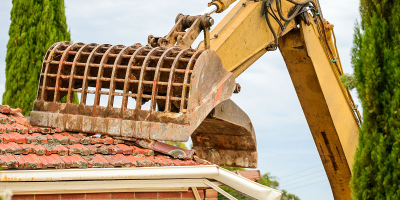 excavator tearing down house