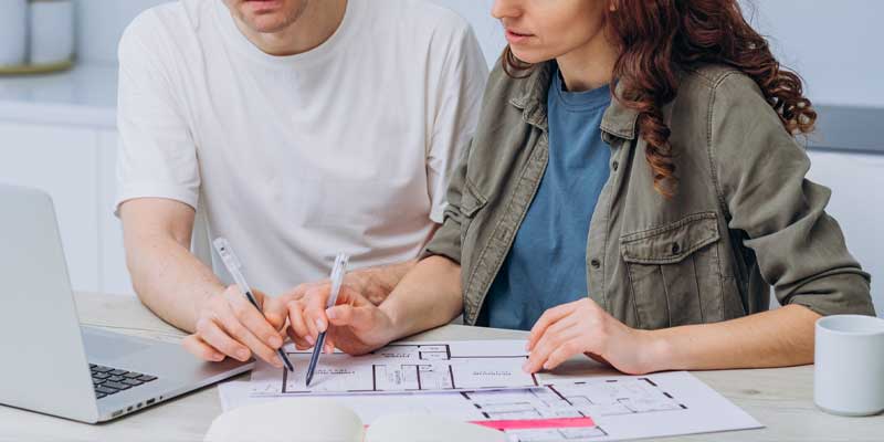 Couple looking over and discussing property blueprint