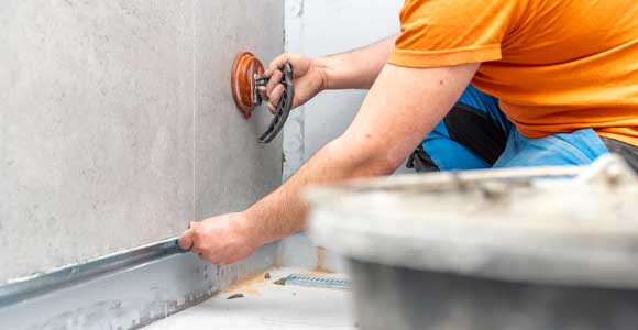 contractor installing new bathroom tile