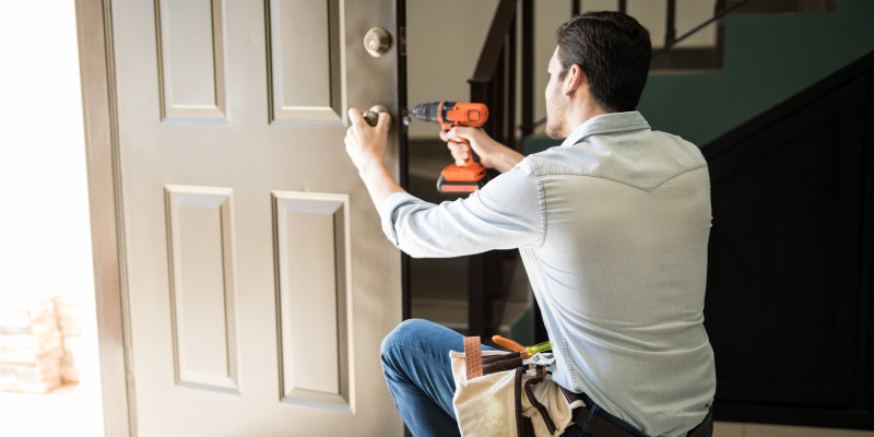 man replacing front door hardware