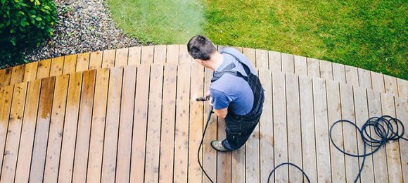 man power washing wood deck