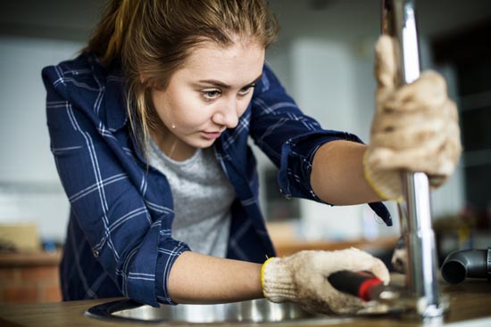 woman removing kitchen faucet