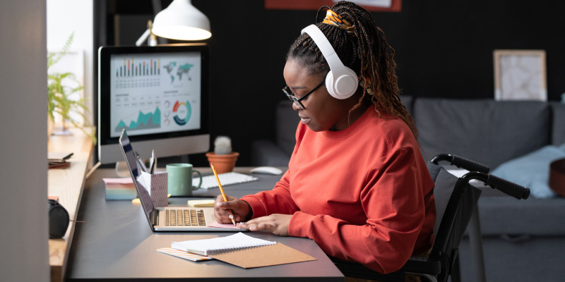 woman sitting at desk in front of window with overhead lamp