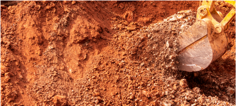 closeup of backhoe filling in pool with dirt